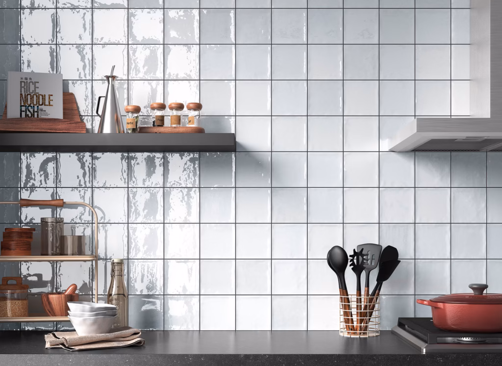 Kitchen workspace with a tile backsplash, wooden shelf holding herb and pepper jars, a metal oil cruet, bowls, and a utensil stand.