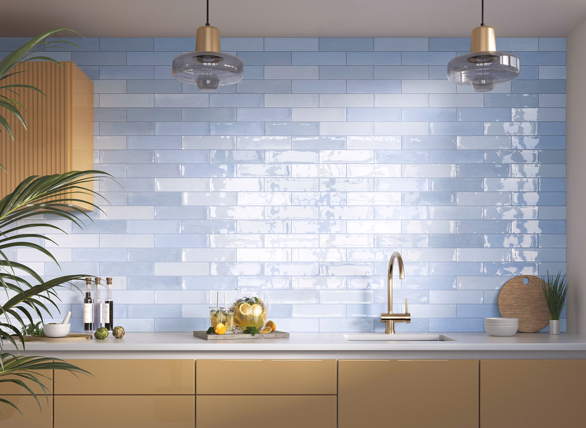 Modern kitchen scene with blue glossy tile backsplash, gold faucet, and two pendant lights.