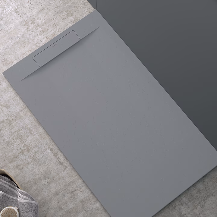 Large gray document folder resting on a concrete floor, with a small tab pocket at the top edge. Description: plain, closed folder on textured surface.