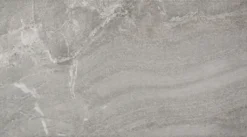 Close-up of a gray stone surface with natural veining and rough texture.
